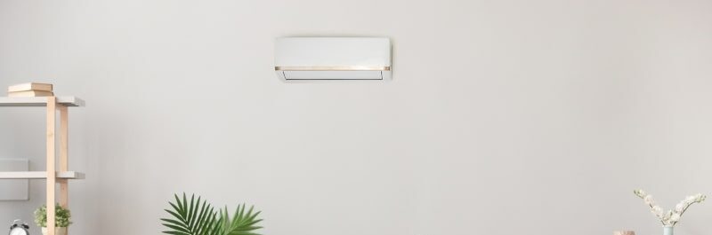 woman laying on couch controlling temperature with ductless ac